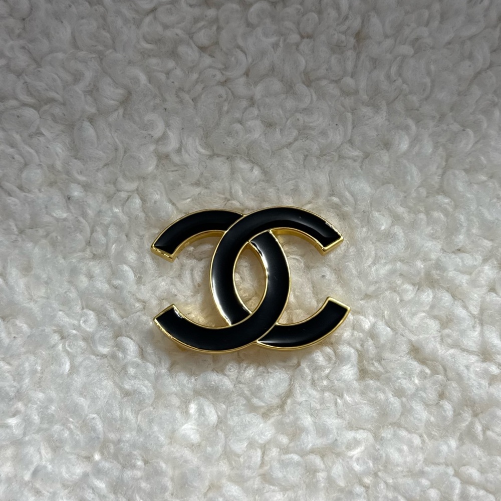 Elegant Black and Gold Interlocking Logo Brooch